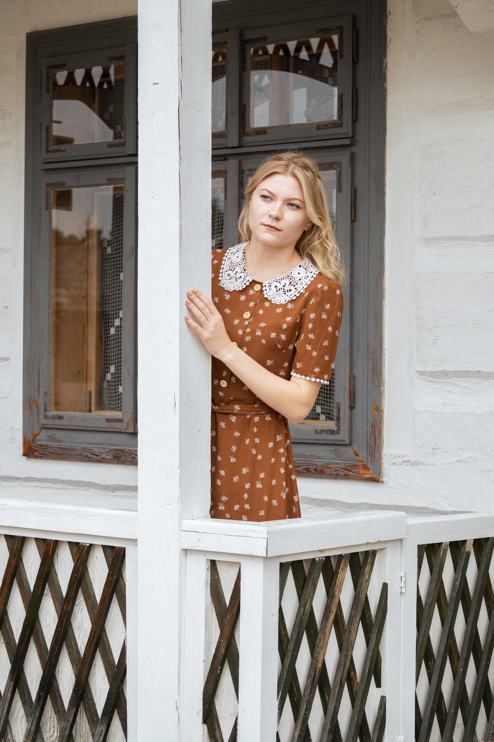 dziewczyna w brązowej sukience wypatruje czegoś w oddali