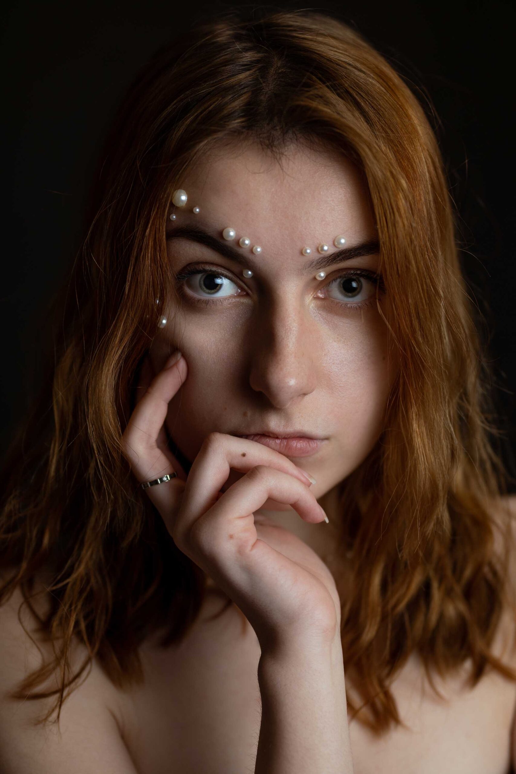 Ruda kobieta z perłami na twarzy. Bliski portret