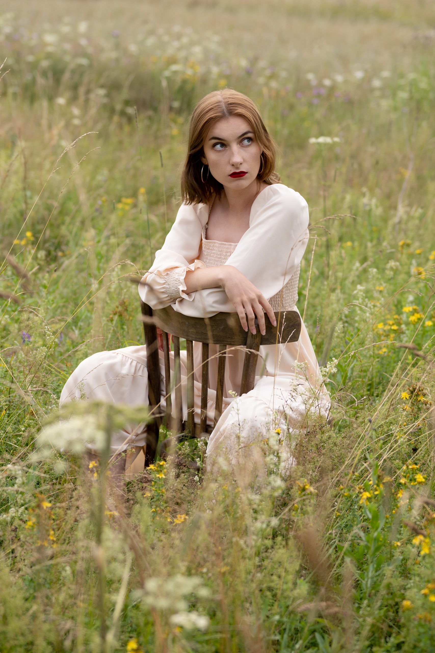 dziewczyna siedzi na łące na krześle