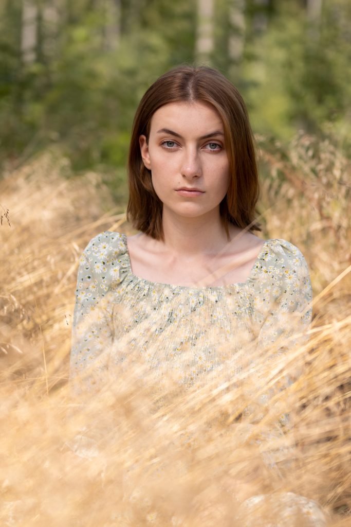 Dziewczyna siedząca w złotej trawie