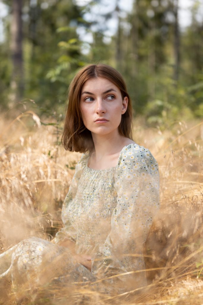 Dziewczyna siedząca w złotej trawie