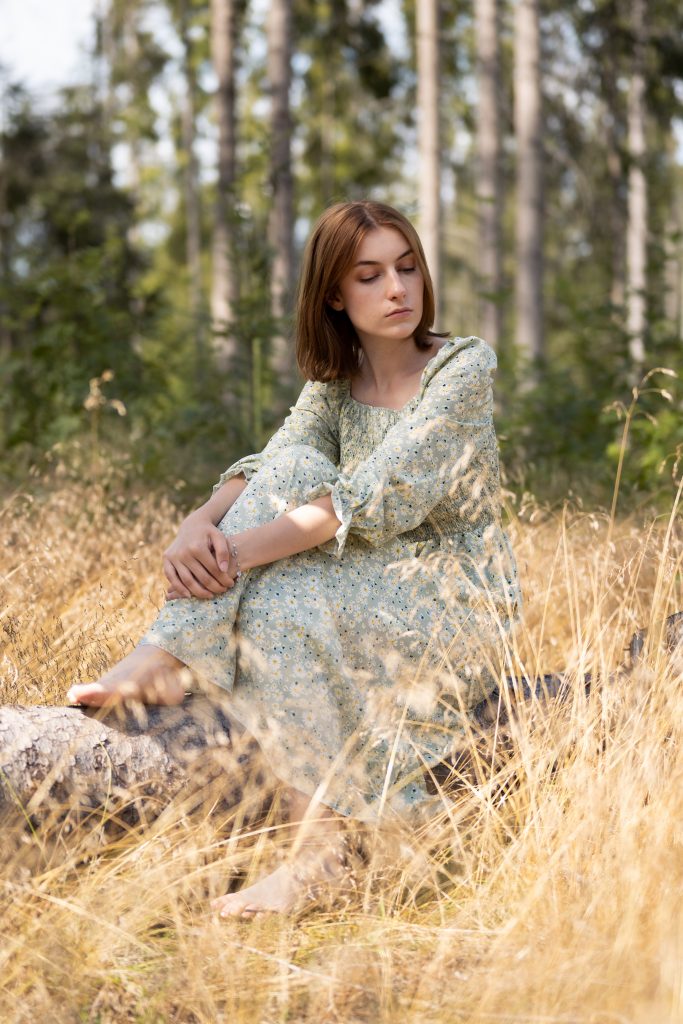 Dziewczyna siedząca w złotej trawie