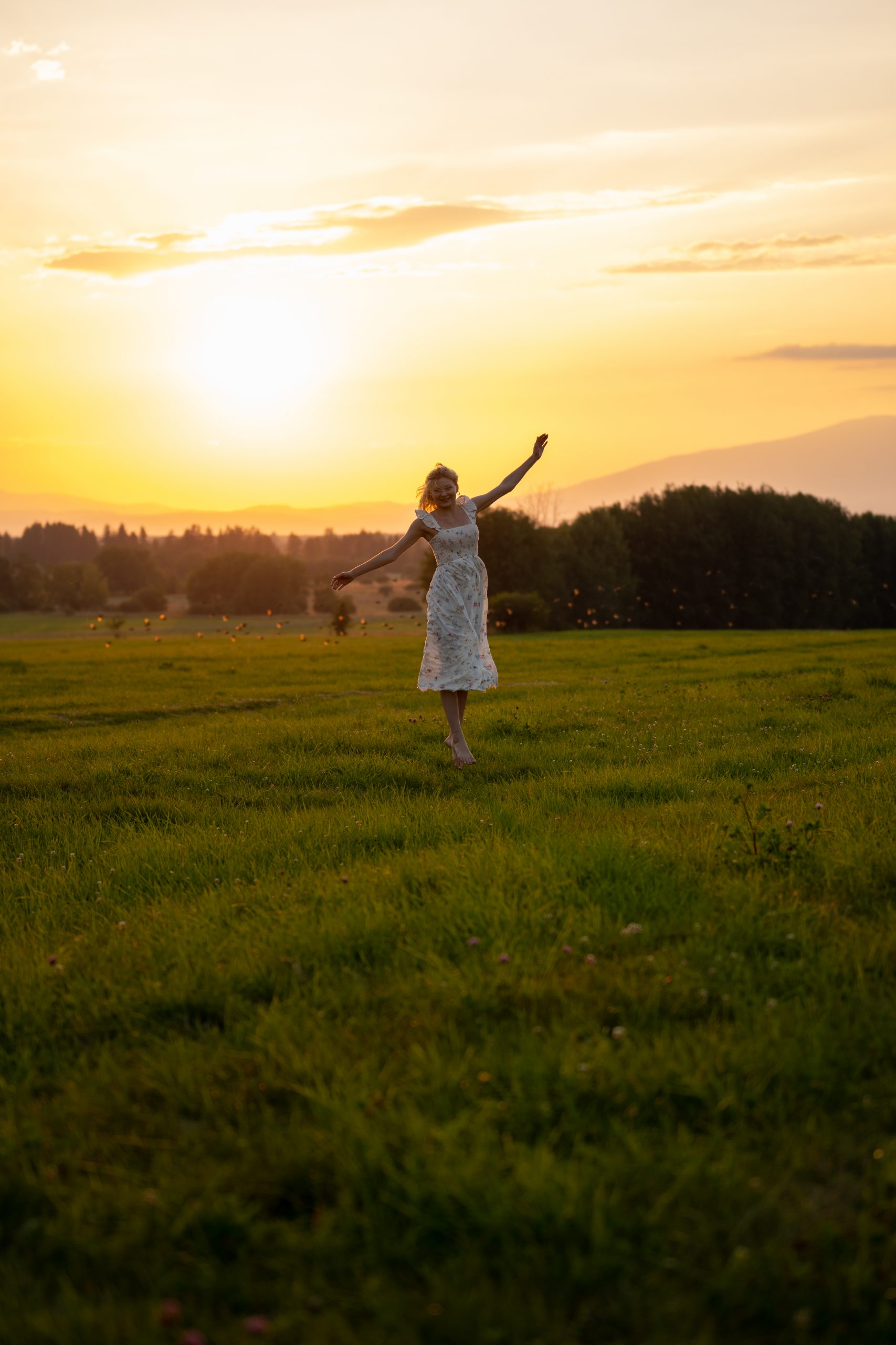Dziewczyna tańcząca na łące o zachodzie słońca