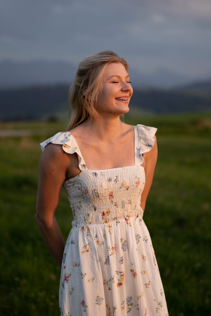 Dziewczyna tańcząca na łące o zachodzie słońca