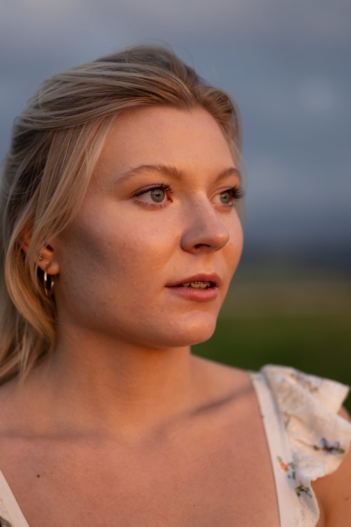 Dziewczyna tańcząca na łące o zachodzie słońca