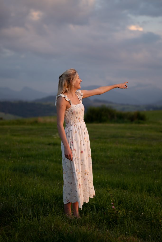 Dziewczyna tańcząca na łące o zachodzie słońca