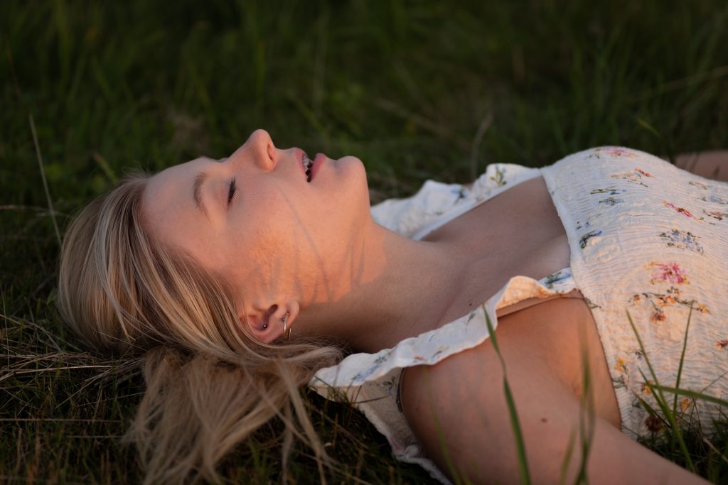 Dziewczyna leżąca na łące o zachodzie słońca
