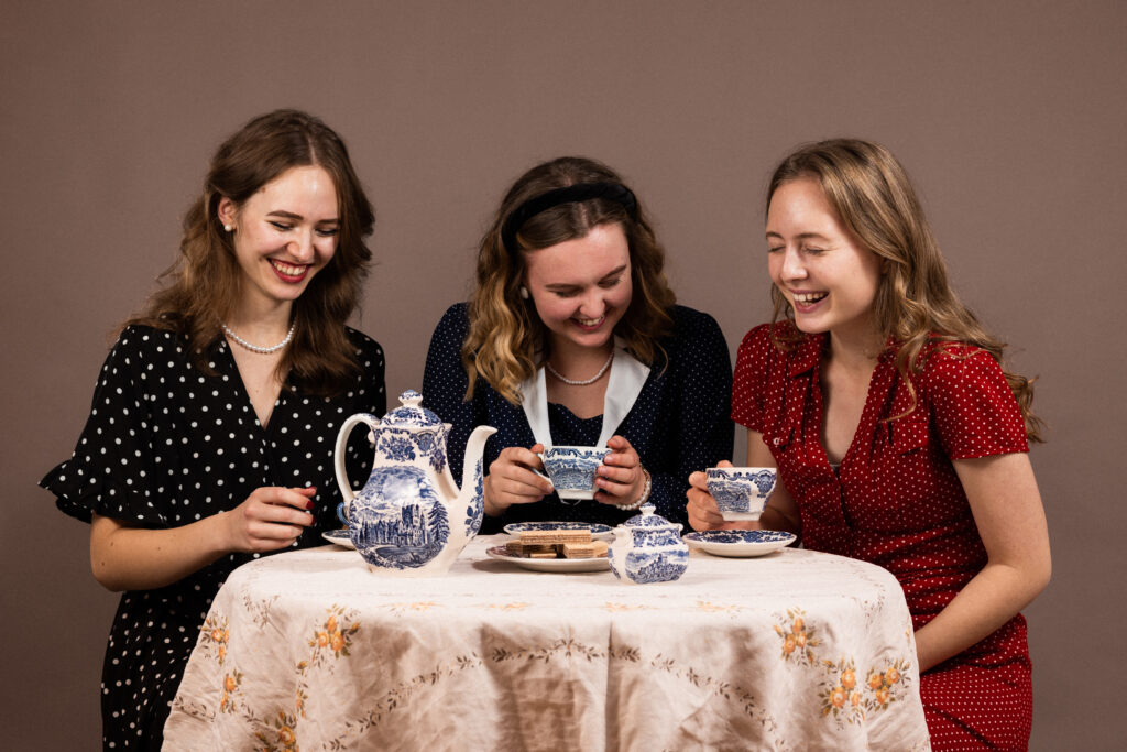 Koleżanki siedzą przy stole w sukienkach w kropki styl retro