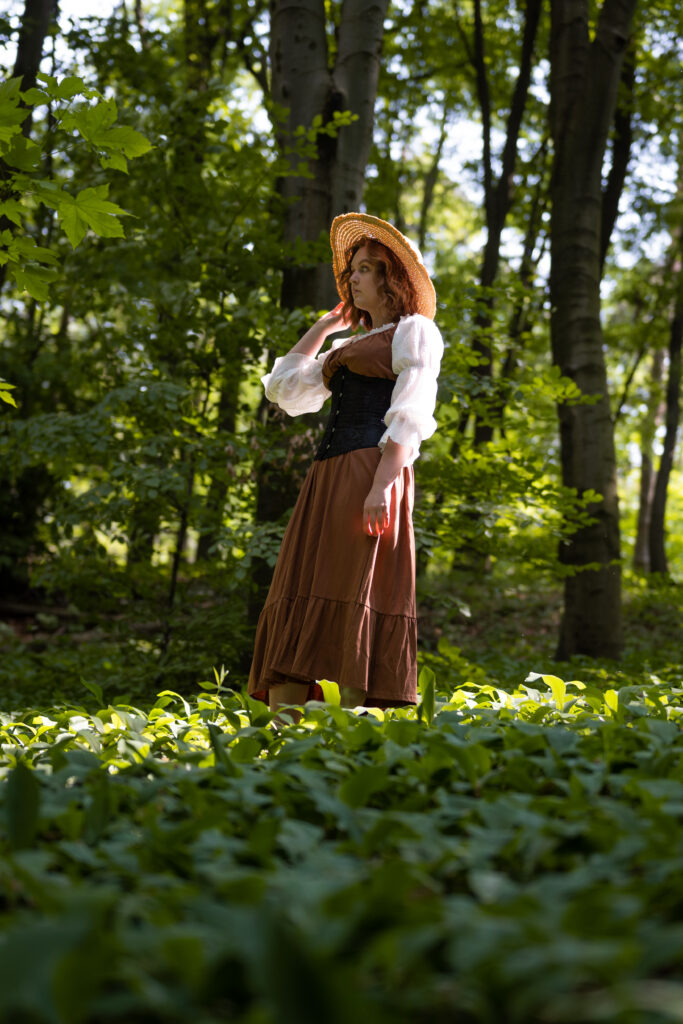 dziewczyna ubrana w brązową sukienkę znajduje się w lesie