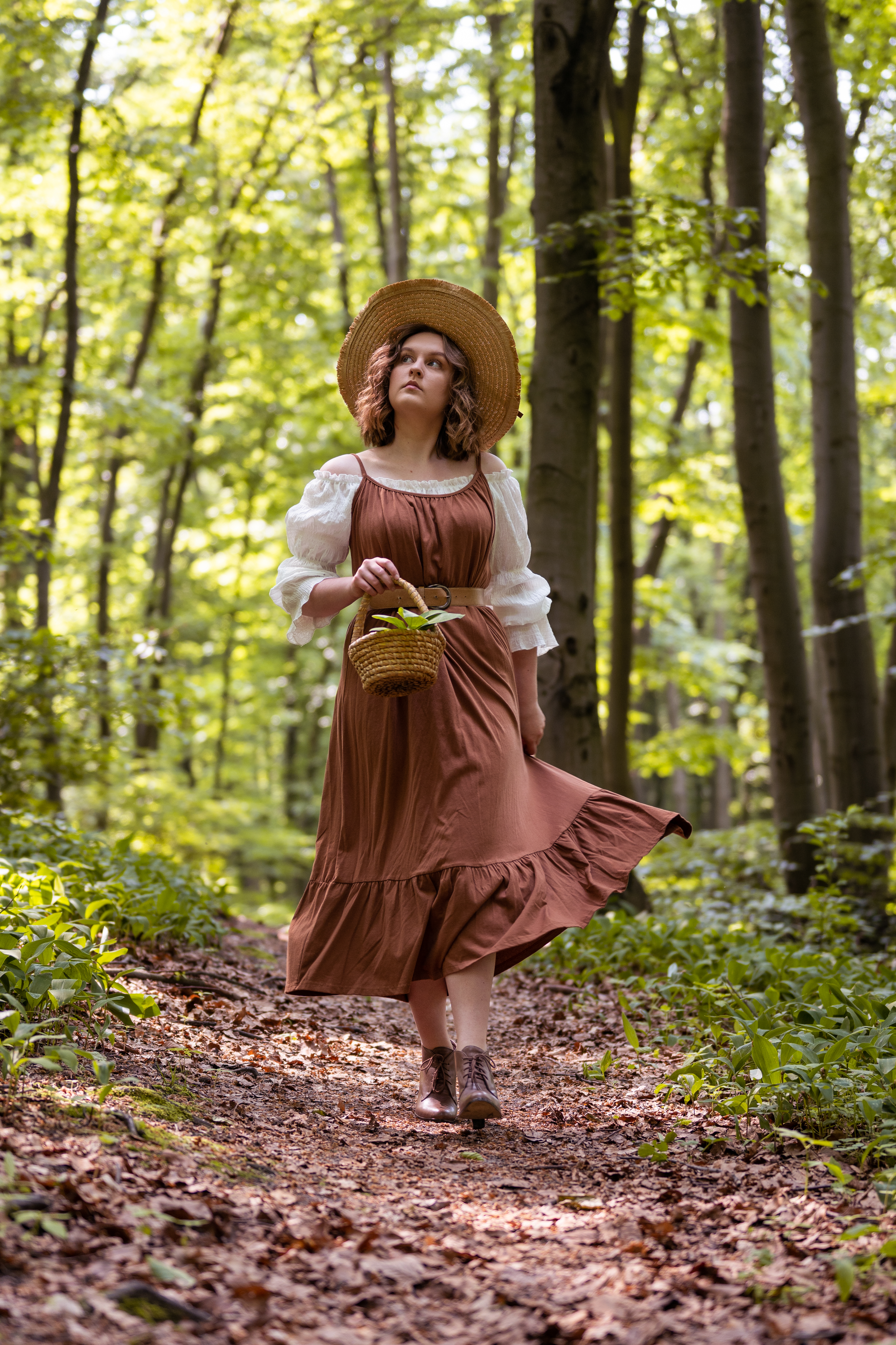 dziewczyna ubrana w brązową sukienkę znajduje się w lesie