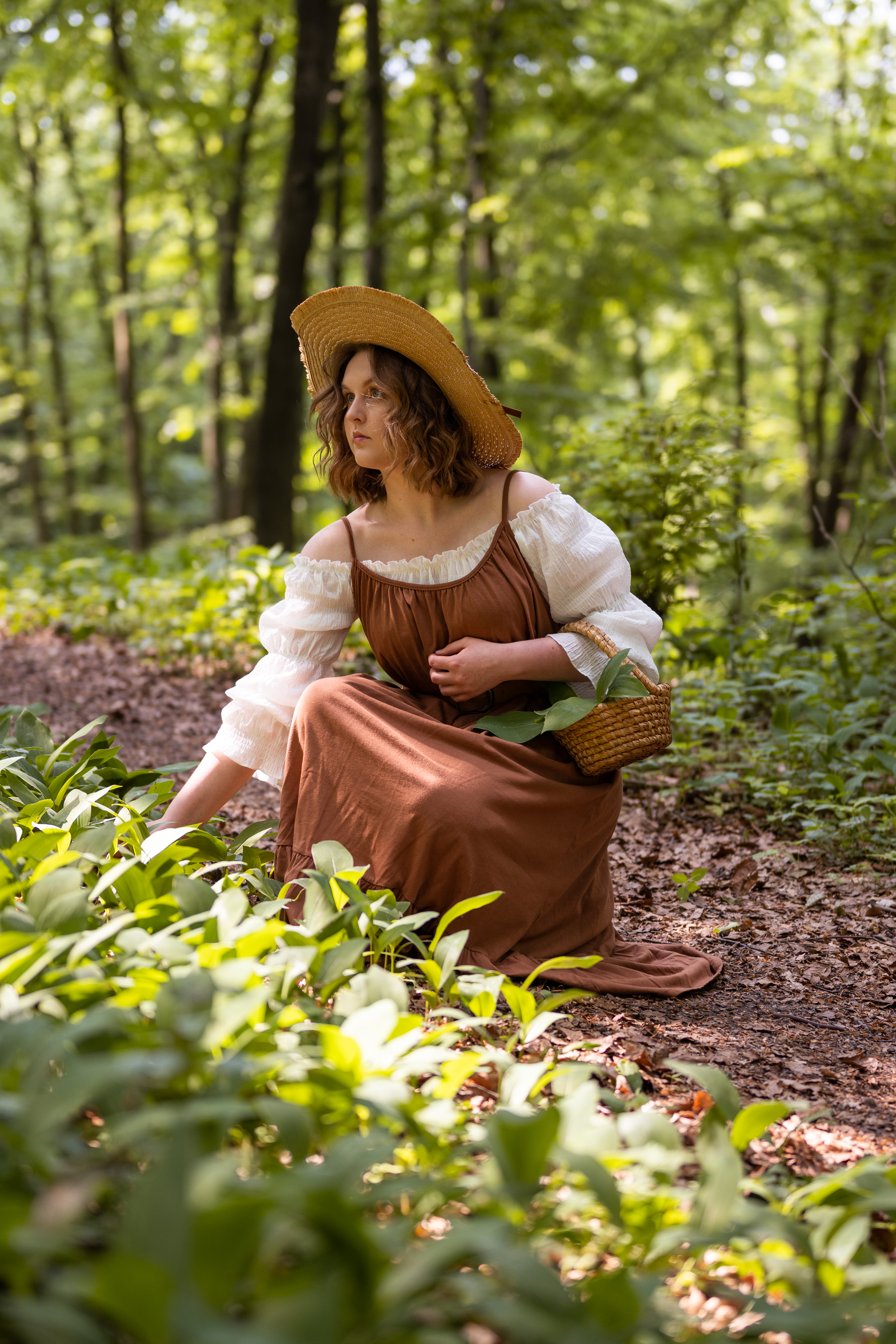 dziewczyna ubrana w brązową sukienkę znajduje się w lesie