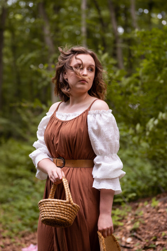 dziewczyna ubrana w brązową sukienkę znajduje się w lesie