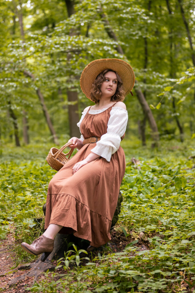 dziewczyna ubrana w brązową sukienkę znajduje się w lesie