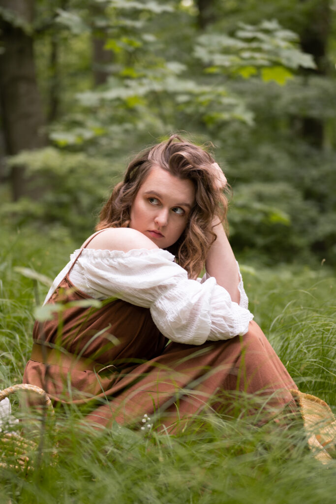 dziewczyna ubrana w brązową sukienkę znajduje się w lesie