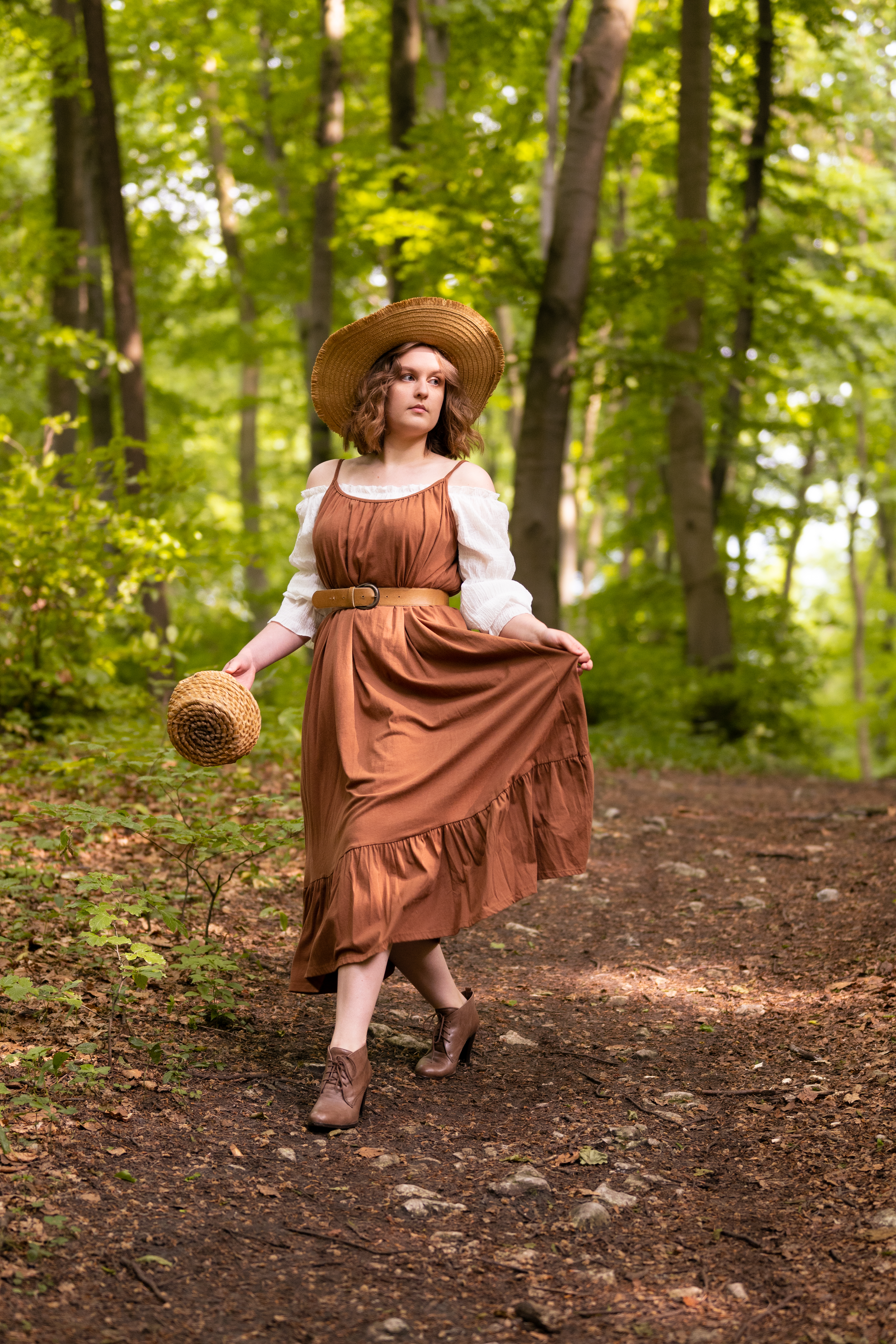 dziewczyna ubrana w brązową sukienkę znajduje się w lesie