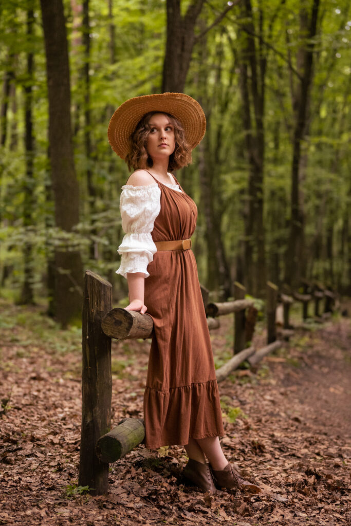 dziewczyna ubrana w brązową sukienkę znajduje się w lesie